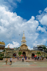 Portrait shot of local people and tourists walking towards the entrance of walled city cartagena,...