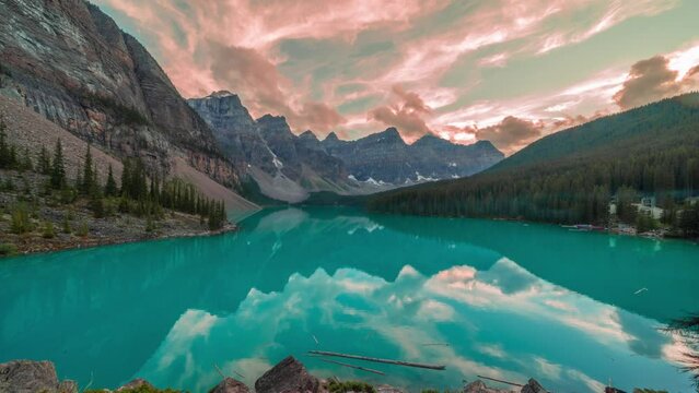 4K time-lapse UHD video of  beautiful view of an iconic famous place, Moraine Lake, a glacier lake located in Banff National Park,Alberta, Canada, in a colorful sunset cloudy summer autumn day. 