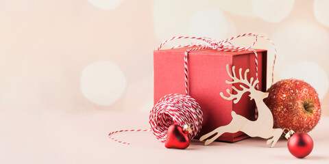  Christmas composition with gift box, christmas decorations, deer and bokeh. Banner. Copy space