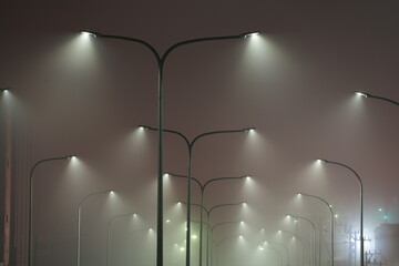 夜霧の中で光る道路照明灯