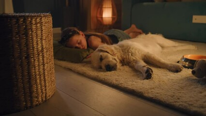 Girl lying on mild carpet with dog, sleeping together, feeling relaxed after saturated day, spending leisure time at home. Golden retriever.
