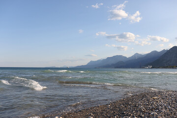 Pebble beach with wavy sea and white foam