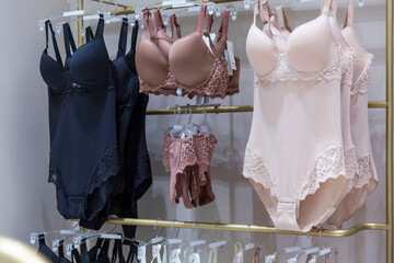 Feminine bodysuits on hangers in a lingerie store. Elegance and sexy.