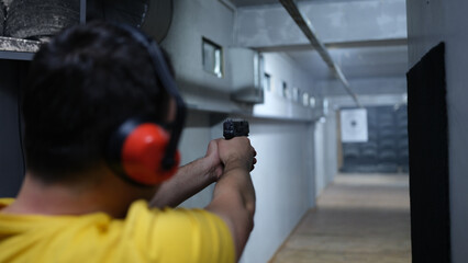 Man shooter in headphones shooting at target
