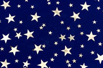Golden stars glitter on blue background. Festive holiday backdrop