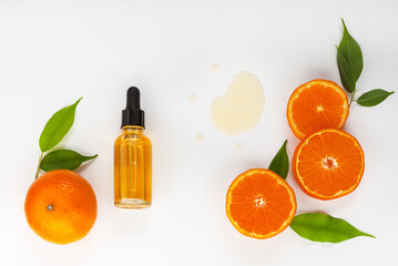 Close-up of sliced juicy tangerine and citrus anti-aging liquid serum with vitamin C and bio...