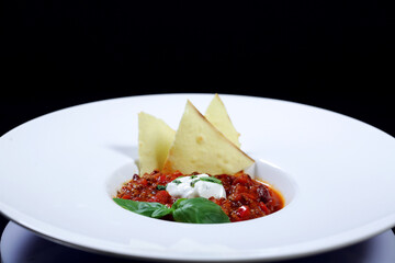 A plate with paste made of eggplants, tomatoes, beans and cream