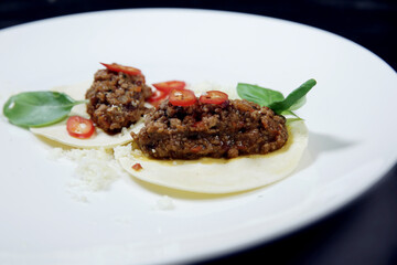 Minced cooked meat on croutons