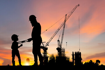 Fototapeta na wymiar Silhouette of father and son with background of new high buildings and construction cranes of evening sunset, Father's Day Concepts