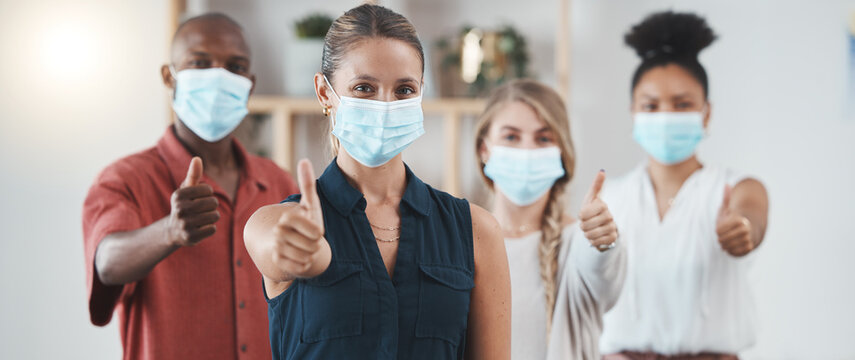 Thumbs up, covid pandemic and staff with mask in business show a positive attitude in workplace. Coronavirus epidemic, employees health and safety policy in office of advertising or marketing company