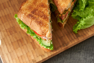 Sandwiches with lettuce leaves on a wooden background, top view.