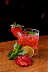 Coloridas bebidas refrescantes para el verano, jugo frío de limonada de fresa con cubitos de hielo en vasos adornados con limones frescos en rodajas