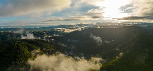 Aerial panorama view of colorful foggy sunset over Resita city, Romania. Captured from a drone.