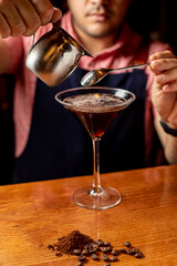 delicioso martini espresso en un vaso junto a granos de café sobre una mesa de madera