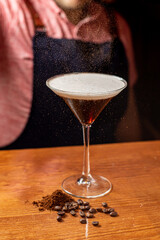 delicioso martini espresso en un vaso junto a granos de café sobre una mesa de madera