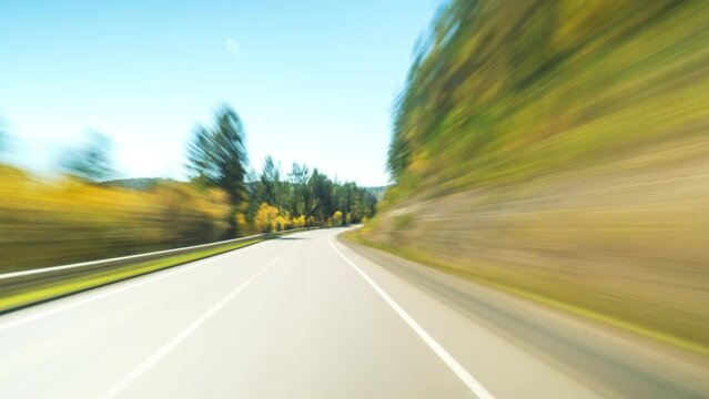 Fast Car Hyperlapse. Car Driving On Country Road in Forest. 4K Point of View Hyperlapse Time-lapse. Trees Stretch on Both Sides Of Road. Road Trip Travel Concept Sort of Dashcam POV