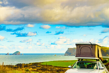 Car with roof top tent camp on sea shore