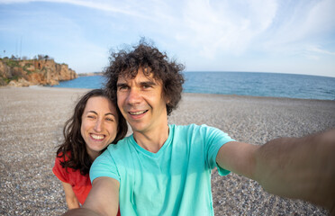 Obraz premium A man and a woman take a selfie on the seashore