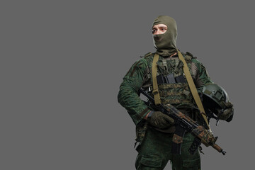 Shot of russian armed forces soldier dressed in uniform and balaclava holding rifle.