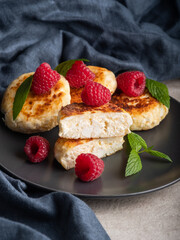 Cheesecakes with mint, raspberries, honey. Ukrainian, Russian cuisine breakfast meal. Homemade food.