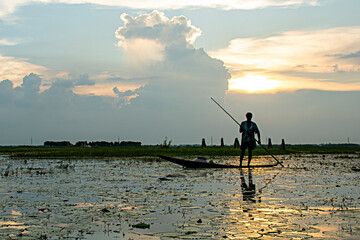 Swamp in the dusk with boating a boatman