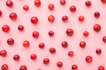 Fresh red cranberries on light pink table background. Pastel color. Berries pattern. Closeup. Top...