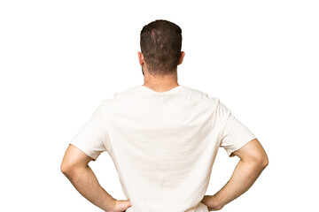 Young handsome caucasian man isolated on green chroma background in back position