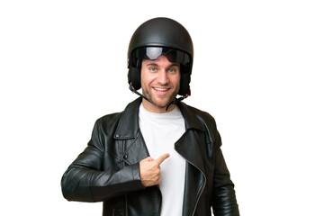 Young caucasian man with a motorcycle helmet isolated on green chroma background with surprise facial expression