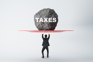Burden of tax payments concept with businessman back view prevents huge stone from falling on his...