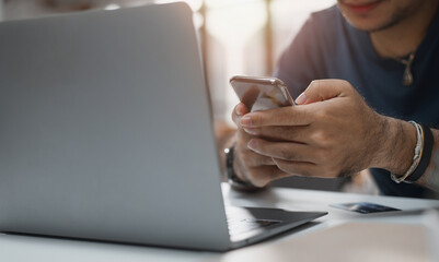 Fototapeta premium Hands holding smartphones and laptops for online banking networks. Digital payments online and online shopping. marketing and finance technology for connecting to a global internet network.