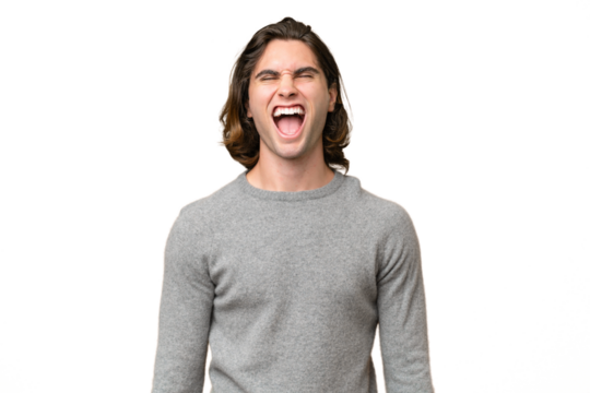 Young caucasian man isolated on green chroma background shouting to the front with mouth wide open
