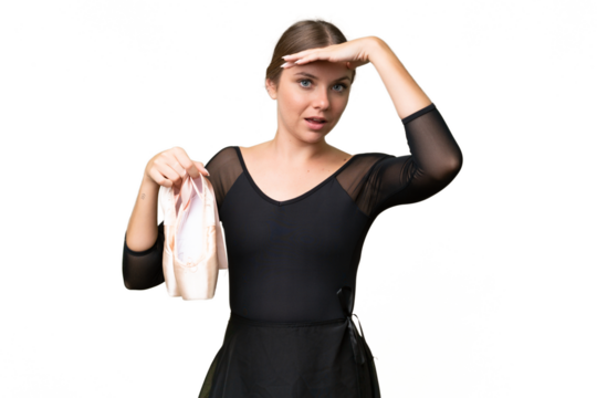 Young beautiful blonde woman practicing ballet over isolated background doing surprise gesture while looking to the side