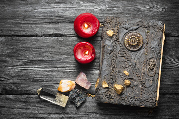 Old magic book and magical minerals on the wooden table flat lay background with copy space.