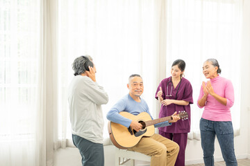 Group of senior people enjoying with activities together with doctor. Elderly people having fun concept. Happy senior playing guitar and singing songs having fun together.