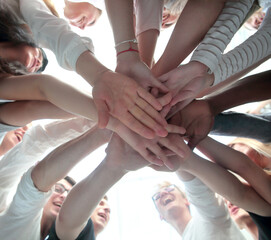bottom view . group of young people joining their palms together