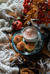 Obraz na płótnie Canvas Cozy morning - cappuccino, cinnamon rolls, cozy blankets. Autumn mood home