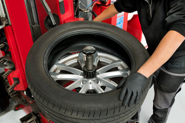 Mechanic Removing Tire From Wheel At Workshop