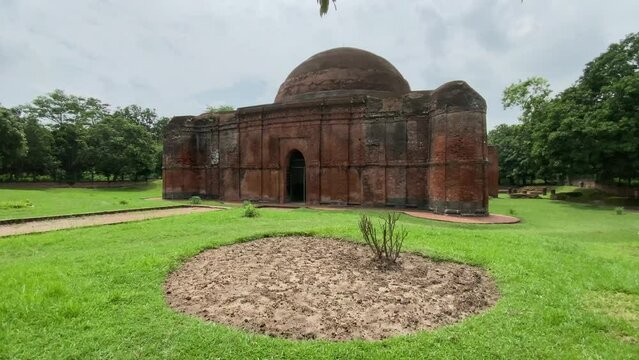 Cinematic shot of the Tantipara Mosque in Gaur, West Bengal's Malda District. The mosque features a two aisles of stone columns, oblong brick construction.
