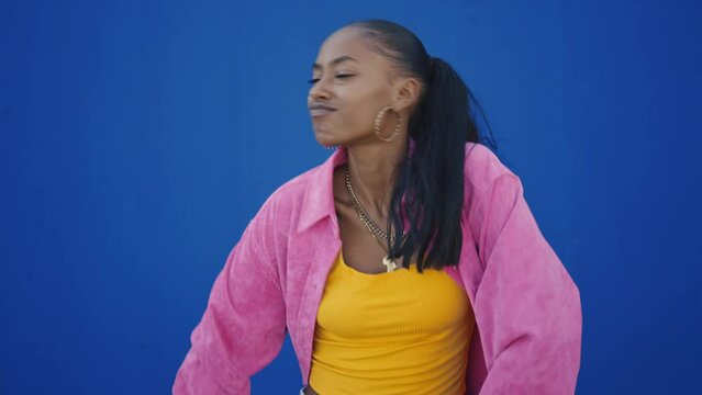 Cinematic footage of a professional hip hop female dancer outddor . Teenager girl with fashionable clothes dancing in a colored modern area of the city