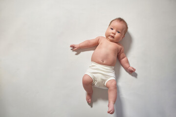 A newborn baby lying full-length on a light-colored surface