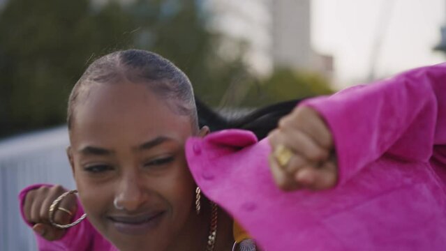 Cinematic footage of a professional hip hop female dancer outddor . Teenager girl with fashionable clothes dancing in a colored modern area of the city