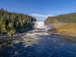Aerial view famous waterfall Tannforsen northern Sweden, with a rainbow in the mist and rapid flowing cascades of water