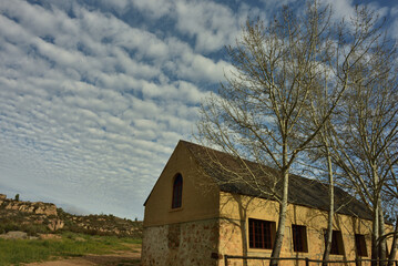 A small rural chapel and budding tree in the Cederberg district with great cloudscape as background