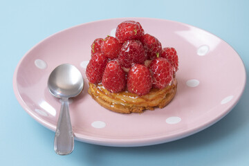 tartelette aux framboises dans une assiette en gros plan