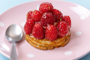 tartelette aux framboises dans une assiette en gros plan