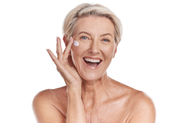 Portrait of one happy mature caucasian woman posing topless against a purple copyspace background. Ageing woman applying cream, moisturiser, sunblock during a skincare routine in a studio