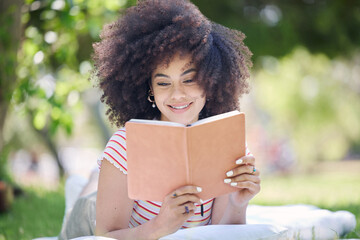 Book, park and black woman reading a story to relax on a picnic in a field during summer. Happy, young and African girl with knowledge from literature for peace and calm on the grass in nature