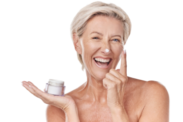 Portrait of one happy mature caucasian woman posing topless against a purple copyspace background. Ageing woman applying cream, moisturiser, sunblock during a skincare routine in a studio