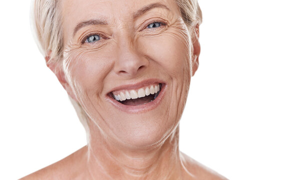Portrait of a happy mature caucasian woman with a bright smile, showing her natural looking veneers while posing against a purple copyspace background. Older woman happy with her oral hygiene