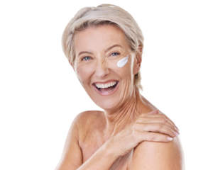 Portrait of one happy mature caucasian woman posing topless against a purple copyspace background. Ageing woman applying cream, moisturiser, sunblock during a skincare routine in a studio